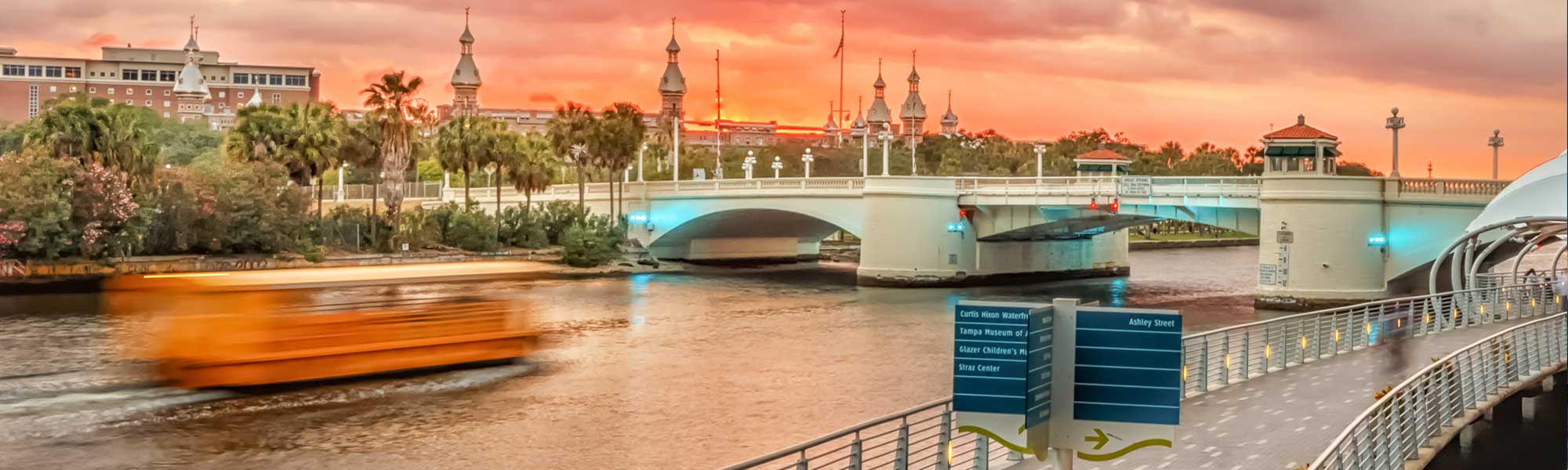 view of hillsborough river from riverwalk at golden hour with pirate water taxi