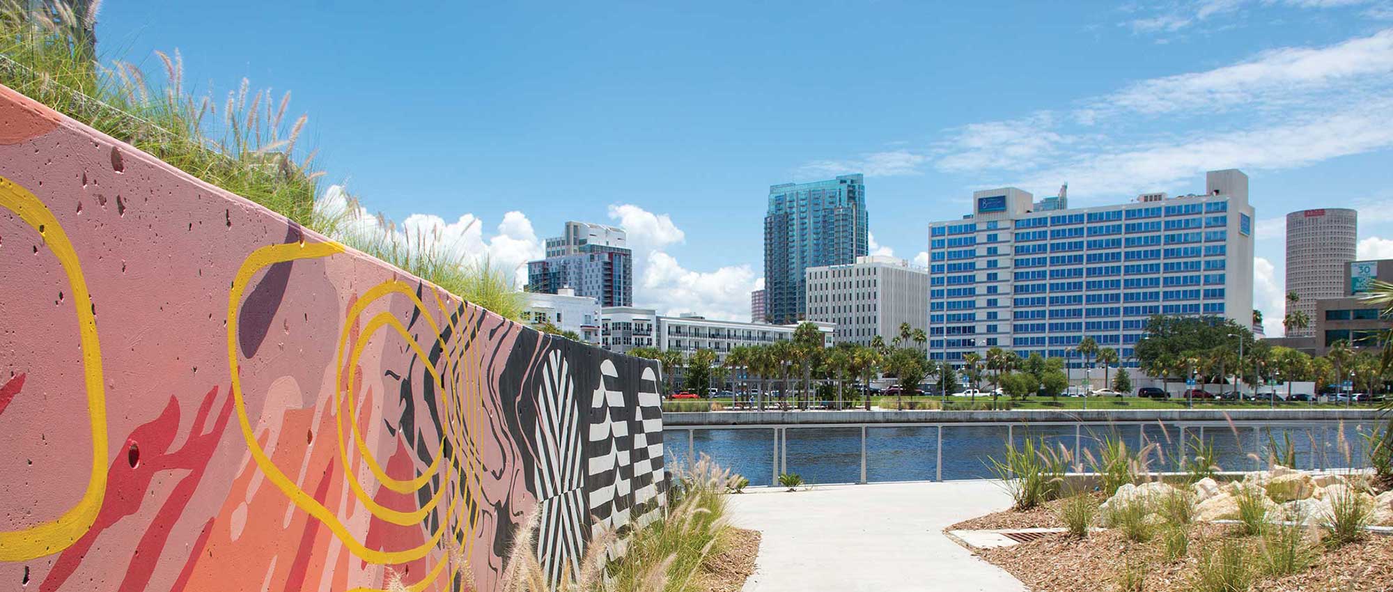 view of barrymore from across river at river center next to pink graffiti art on wall