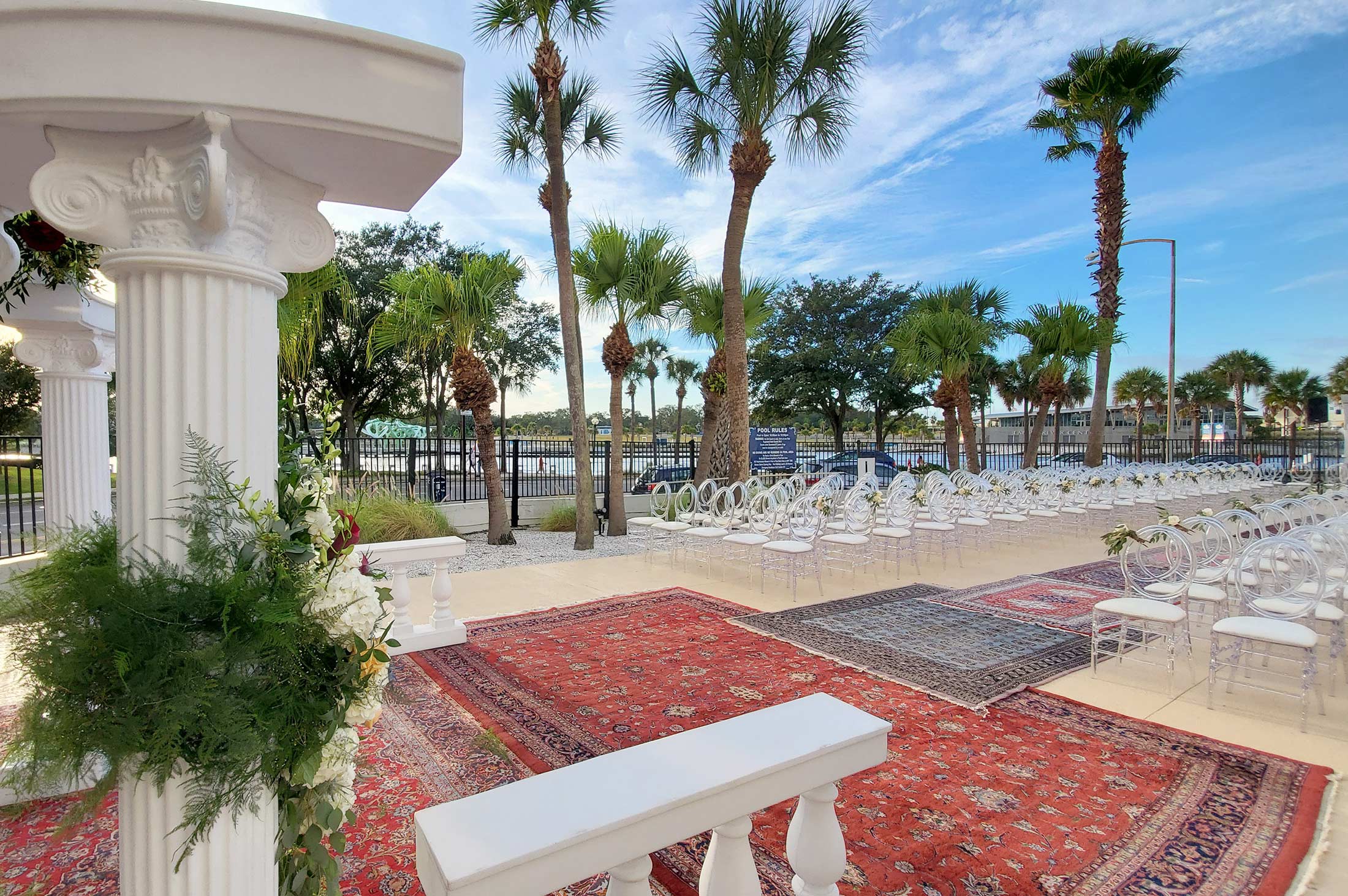 ballrom setup with banquet rounds and tall floral arrangements on tables, live music stage in background